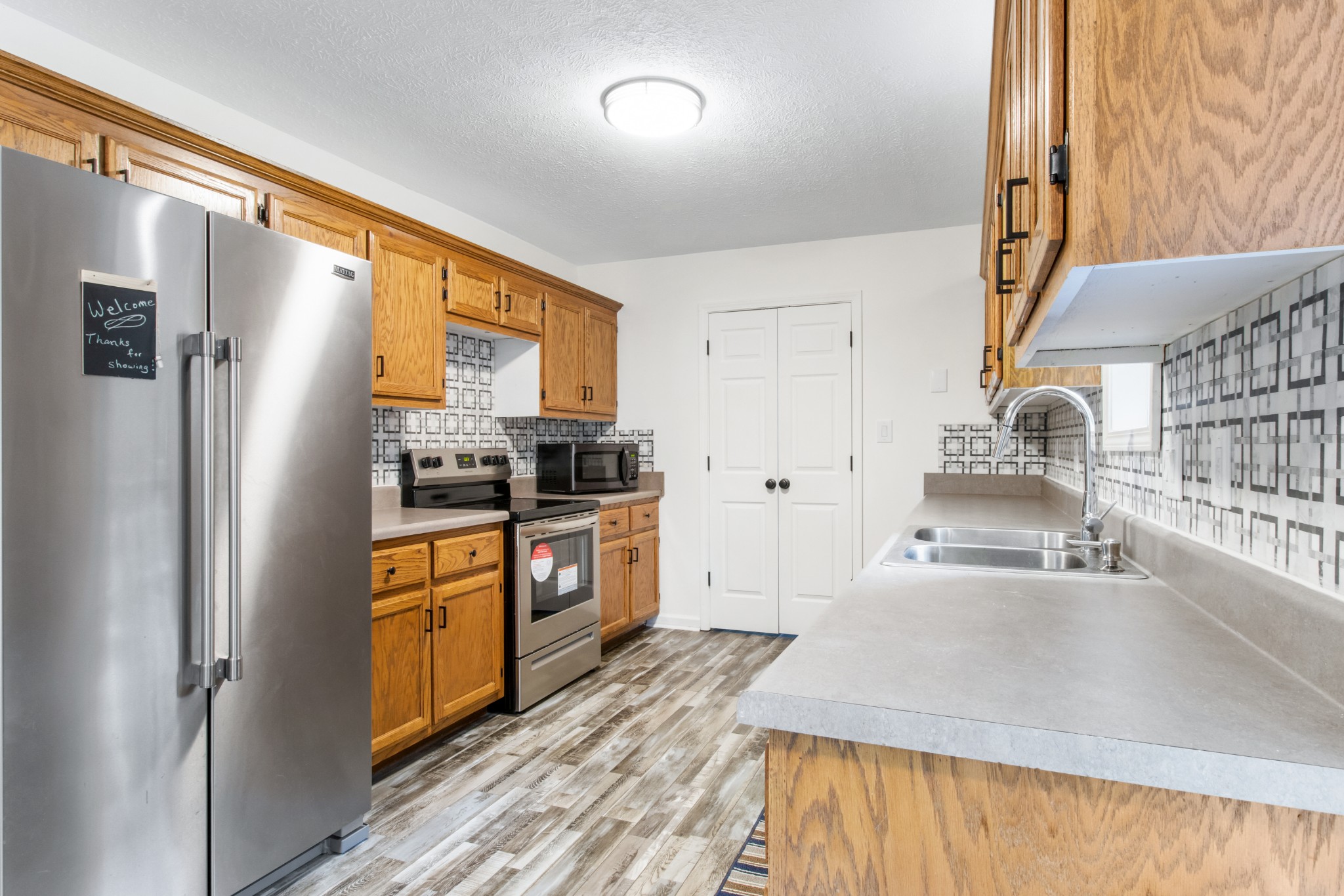 1760 Hazelwood Road Clarksville, TN 37040 - Photo 14 of 34 a kitchen with granite countertop stainless steel appliances a refrigerator stove top oven and sink
