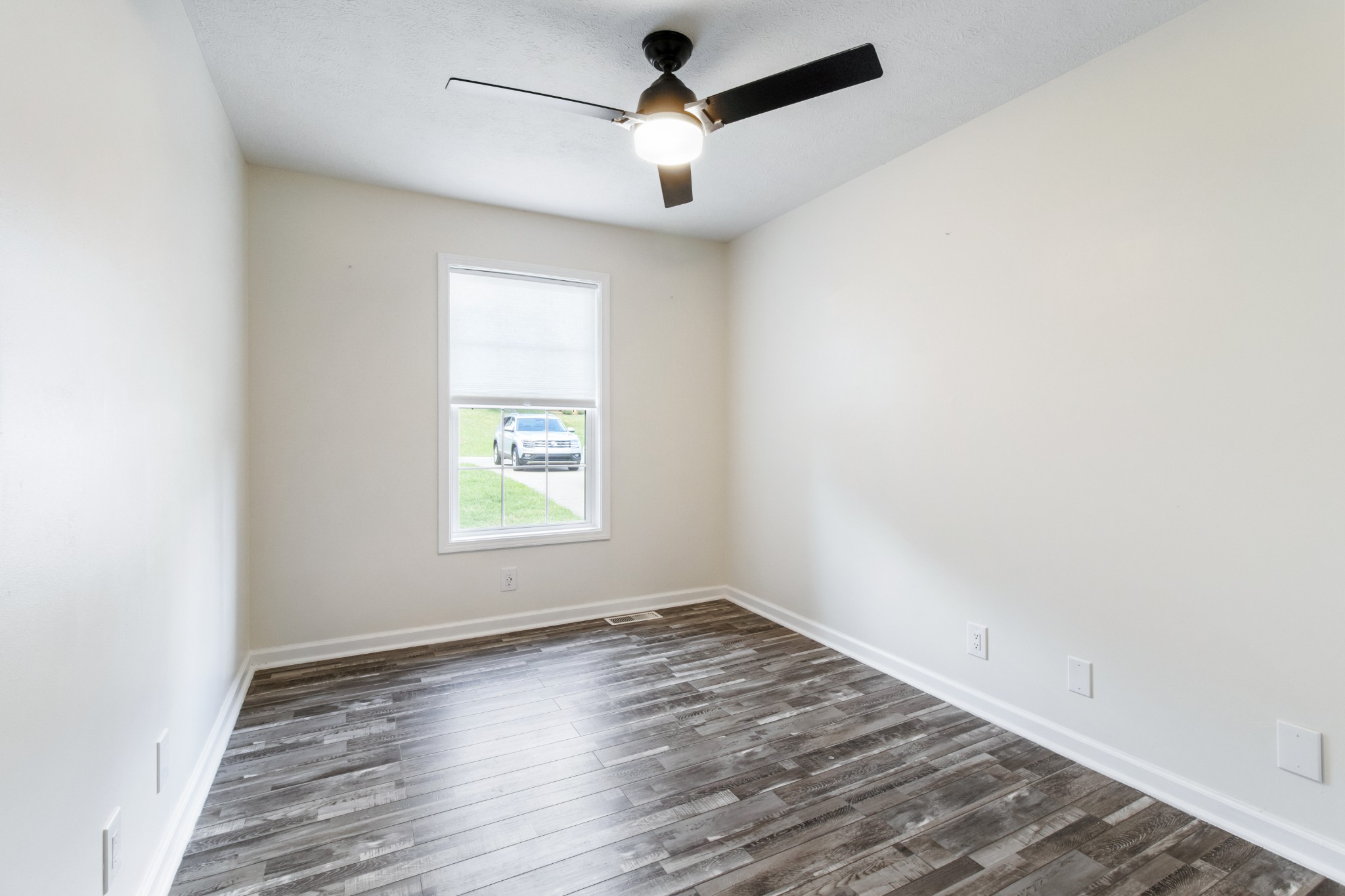 1760 Hazelwood Road Clarksville, TN 37040 - Photo 23 of 34 an empty room with wooden floor ceiling fan and windows