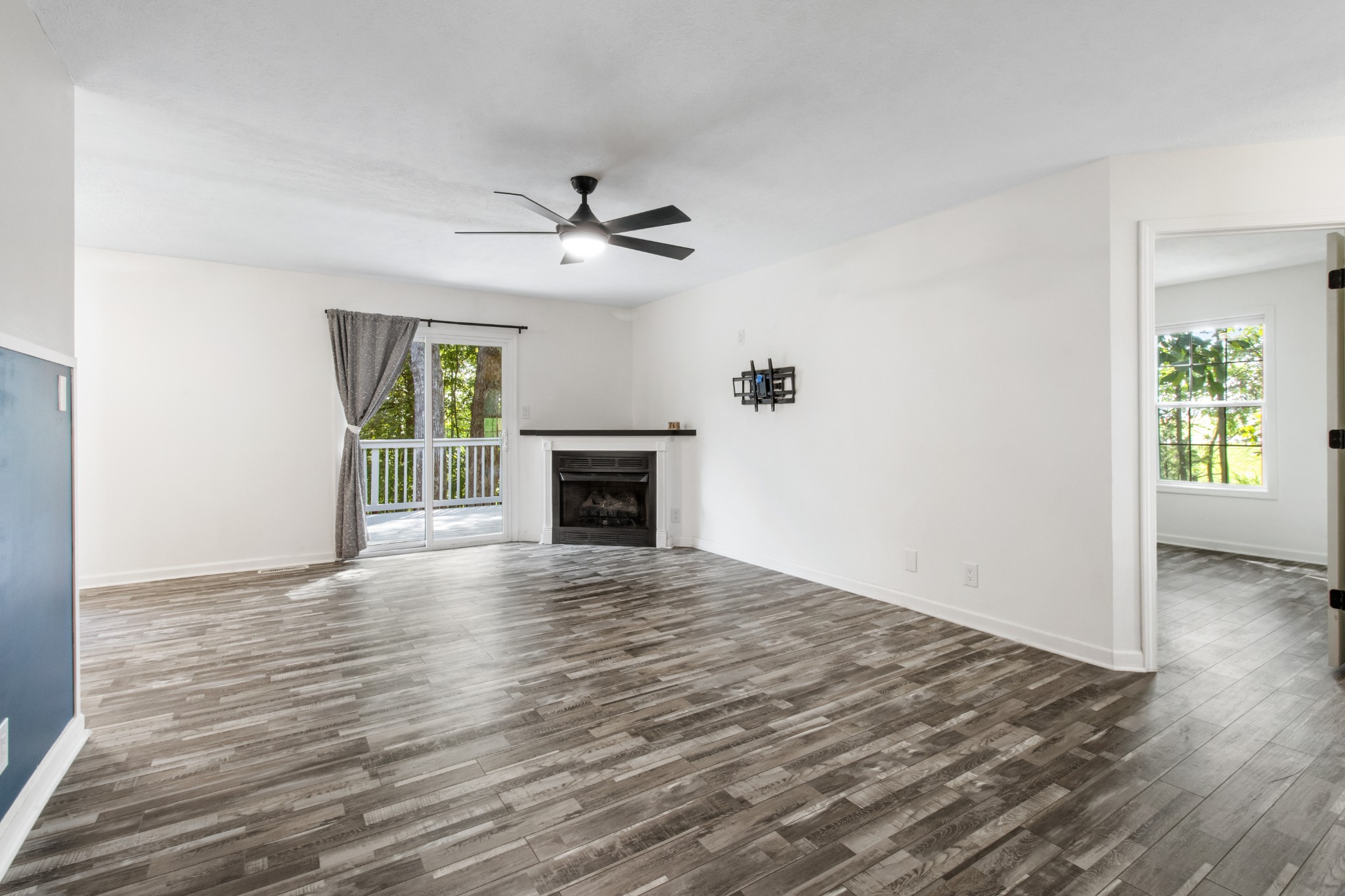 1760 Hazelwood Road Clarksville, TN 37040 - Photo 10 of 34 an empty room with wooden floor fireplace and windows
