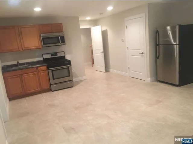 a kitchen with stainless steel appliances granite countertop a refrigerator stove and sink