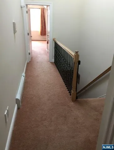 a view of a hallway with wooden floor and windows