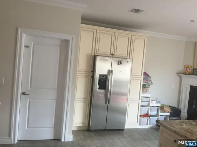 a metallic refrigerator freezer sitting in a kitchen