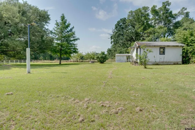 a view of a big yard with a house and large trees