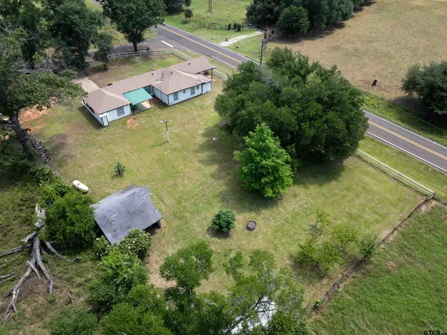 an aerial view of residential house with outdoor space and trees all around