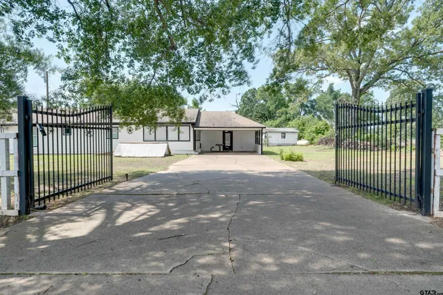 a view of a house with a small yard and fence
