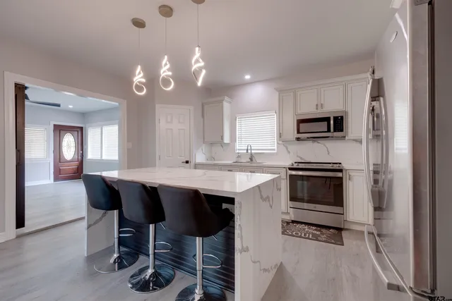 a kitchen with a sink and a stove top oven with wooden floor