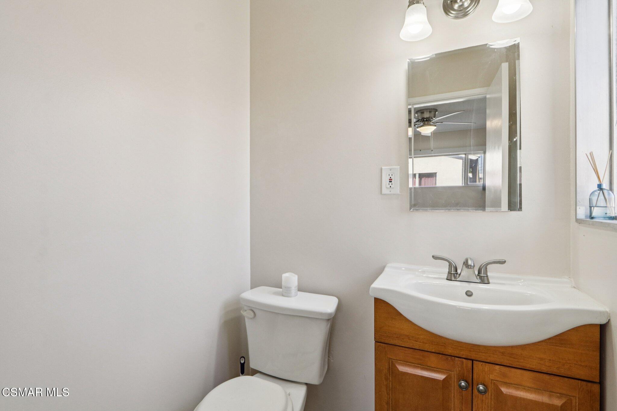 12745 Muscatine Street Pacoima, CA 91331 - Photo 21 of 35 a bathroom with a sink a toilet and mirror
