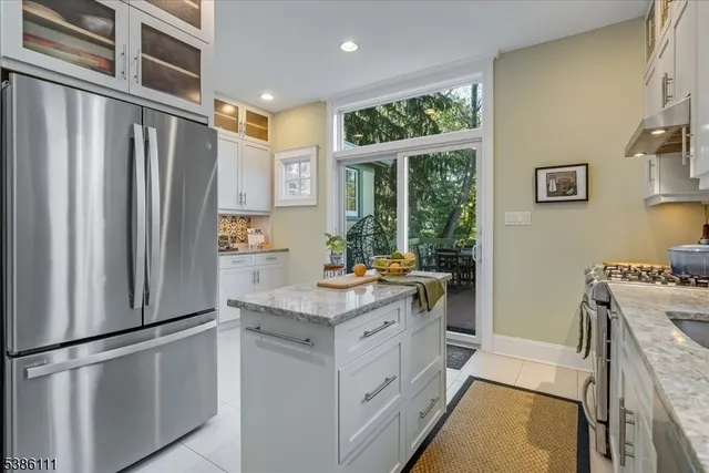 a kitchen with stainless steel appliances granite countertop a stove and white cabinets