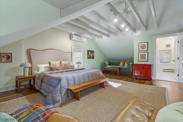 a bedroom with a large bed and wooden floor