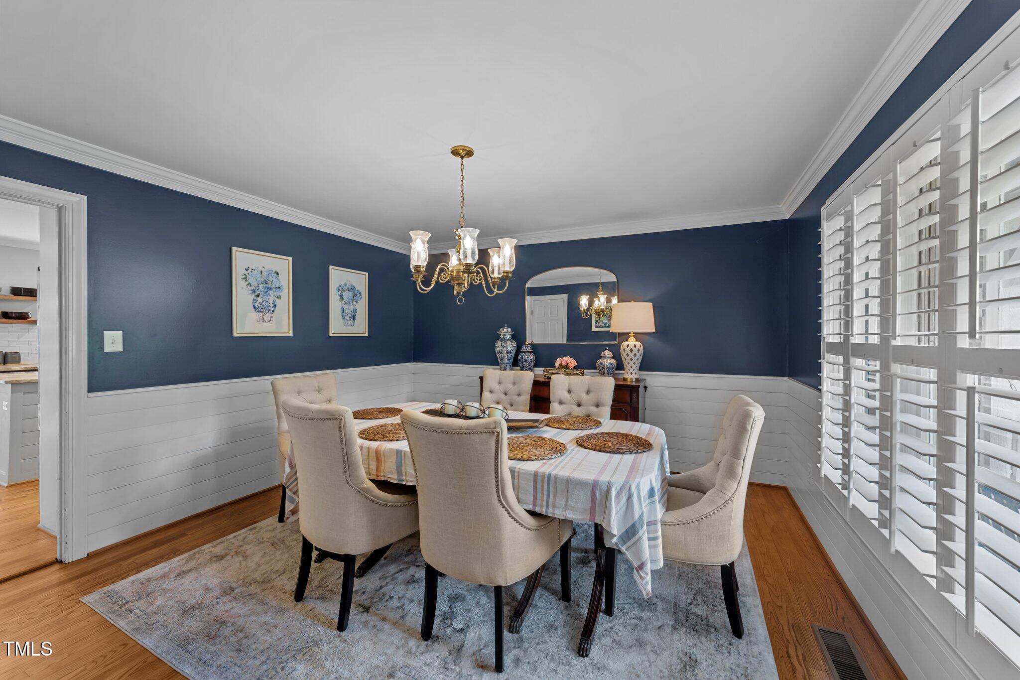 2409 Beechview Court Raleigh, NC 27615 - Photo 19 of 46 a view of a dining room with furniture a chandelier and wooden floor