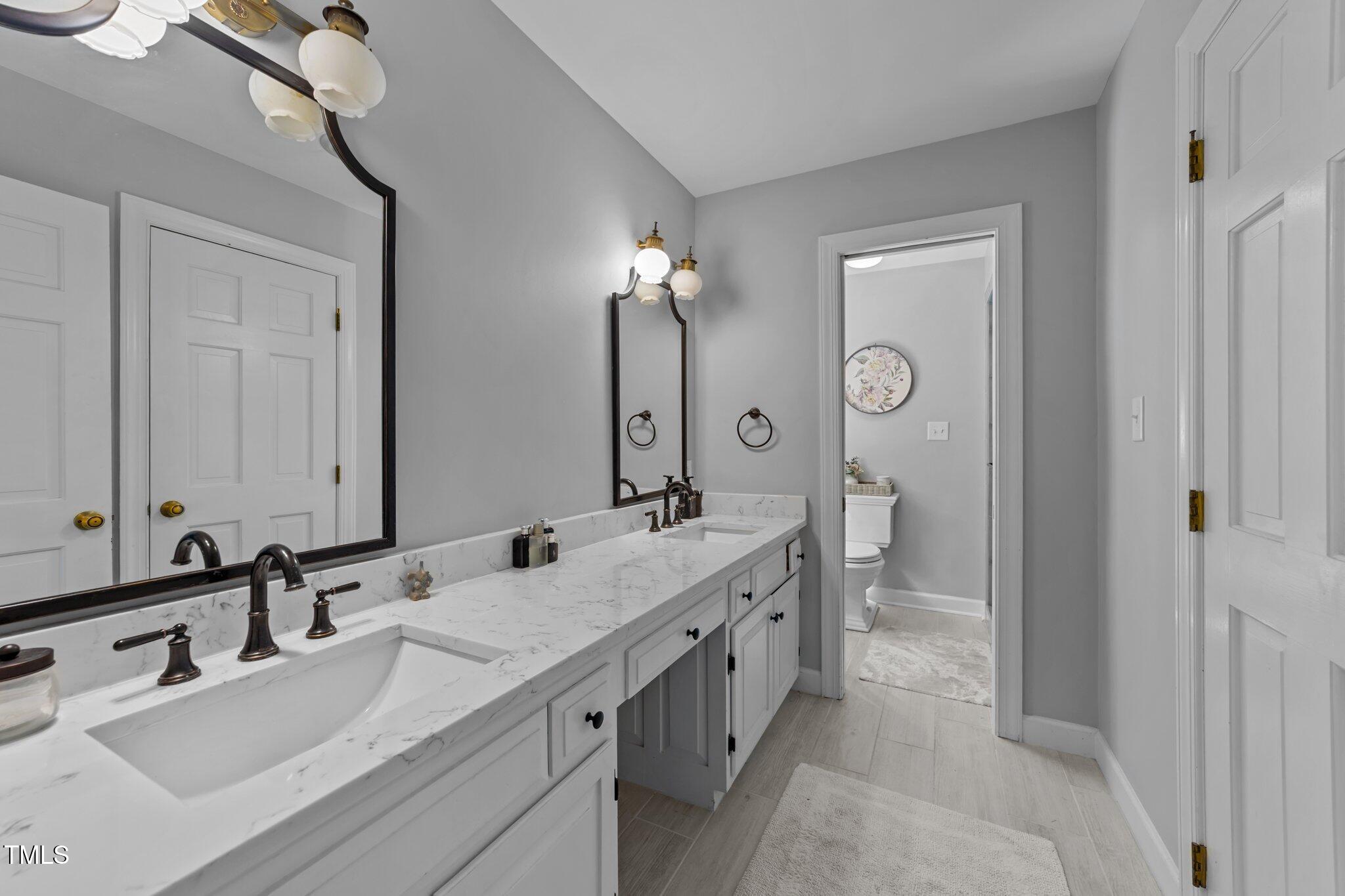 2409 Beechview Court Raleigh, NC 27615 - Photo 22 of 46 a bathroom with a double vanity sink mirror and double