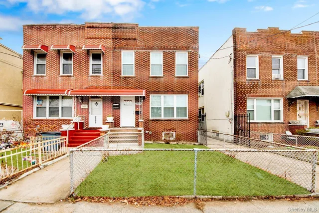 front view of a brick house with a yard