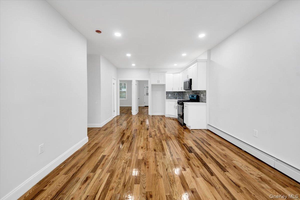 2886 Randall Avenue Bronx, NY 10465 - Photo 13 of 26 living room with a baseboard heating unit, recessed lighting, and light wood-style flooring