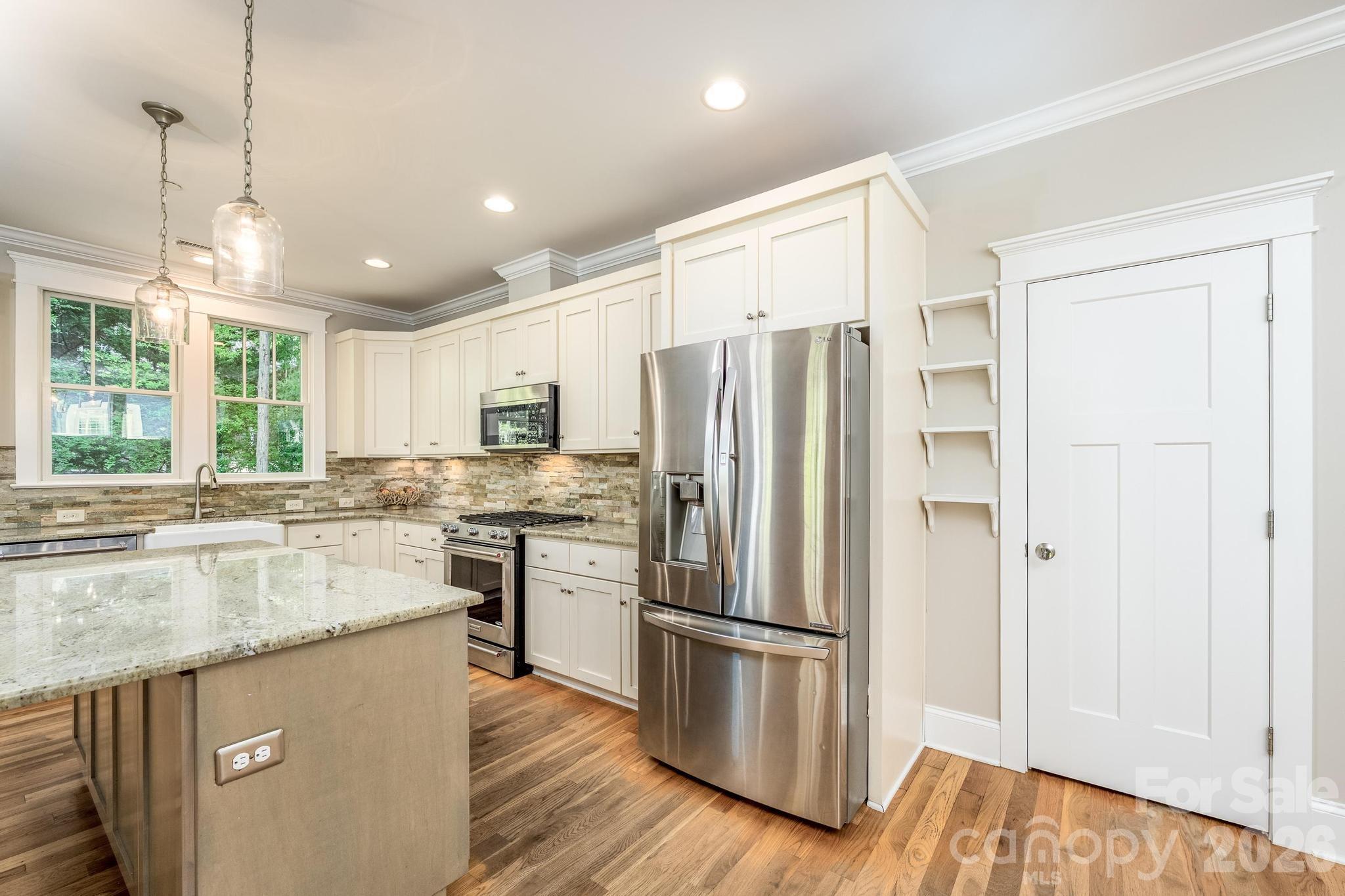 735 Emma Claire Lane Davidson, NC 28036 - Photo 12 of 48 a kitchen with stainless steel appliances granite countertop a refrigerator a stove and a sink with large window