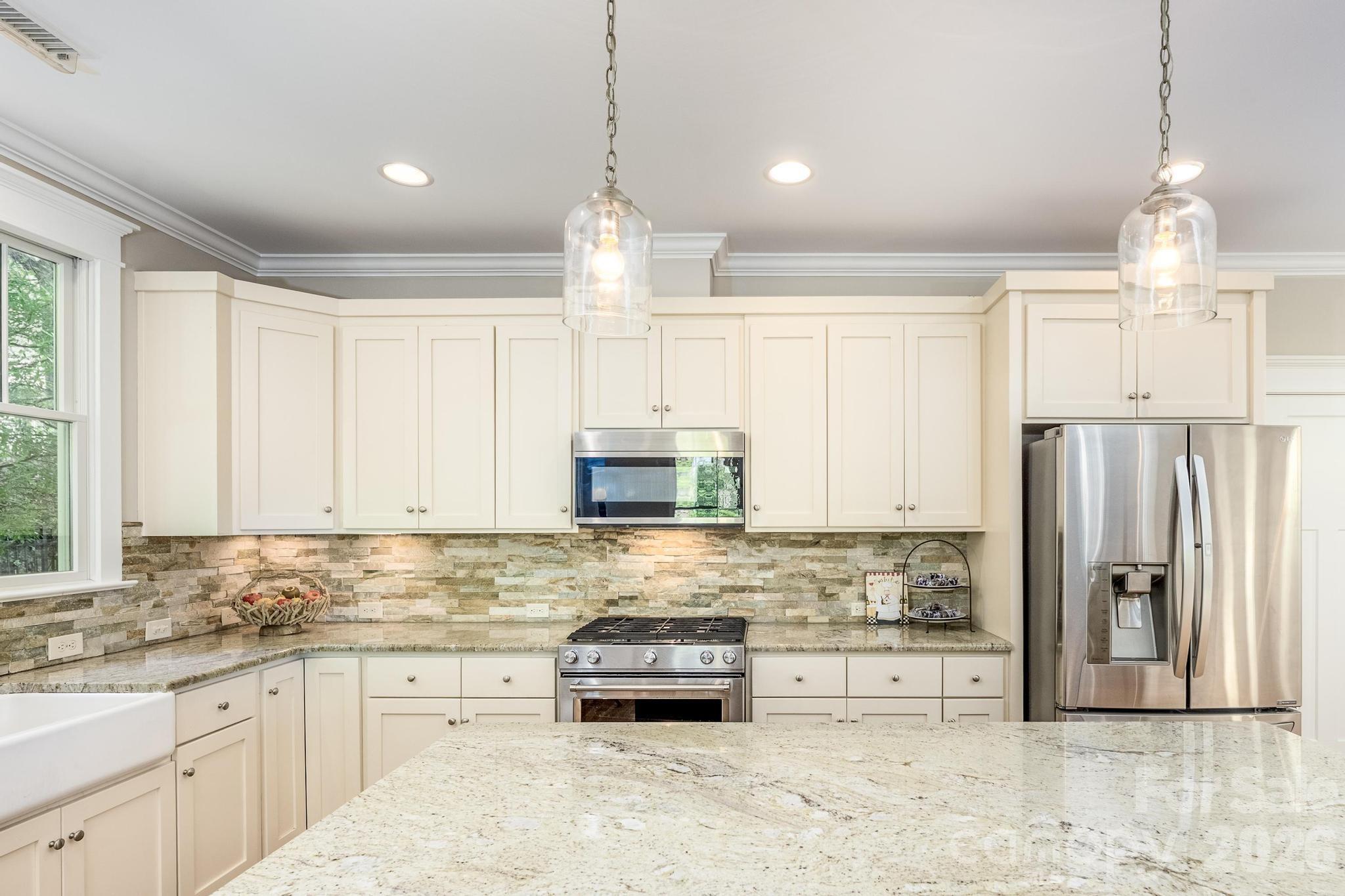 735 Emma Claire Lane Davidson, NC 28036 - Photo 13 of 48 a kitchen with stainless steel appliances granite countertop a refrigerator a stove a sink and white cabinets with wooden floor
