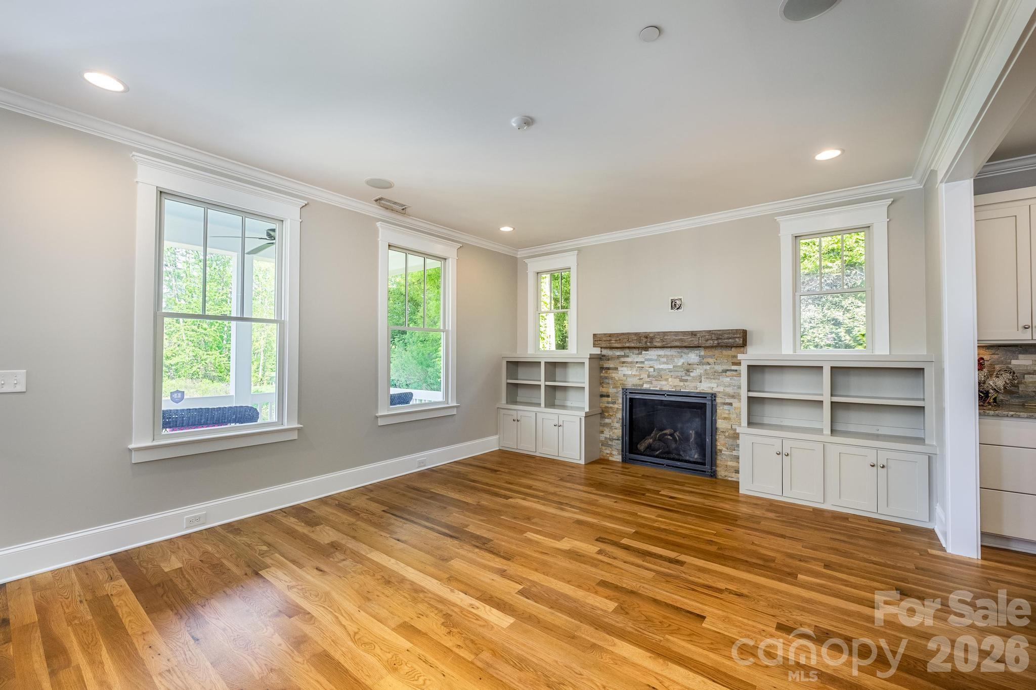 735 Emma Claire Lane Davidson, NC 28036 - Photo 7 of 48 a view of empty room with a fireplace and windows