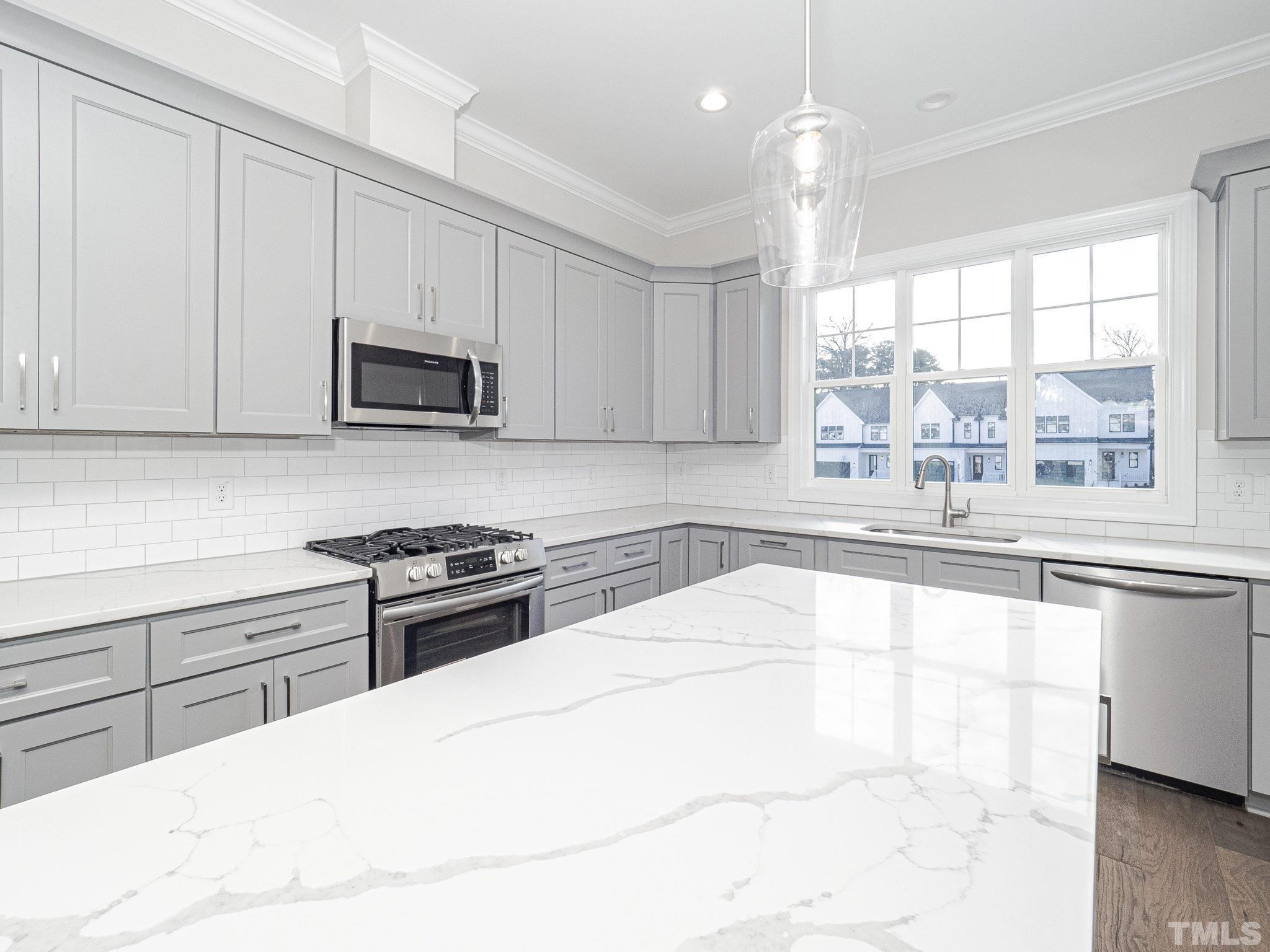 4920 Trek Lane Raleigh, NC 27606 - Photo 12 of 31 a kitchen with stainless steel appliances a stove sink microwave and cabinets
