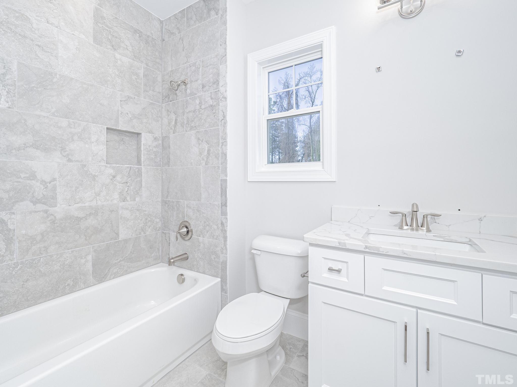 4920 Trek Lane Raleigh, NC 27606 - Photo 20 of 31 a bathroom with a granite countertop toilet a sink and a bathtub