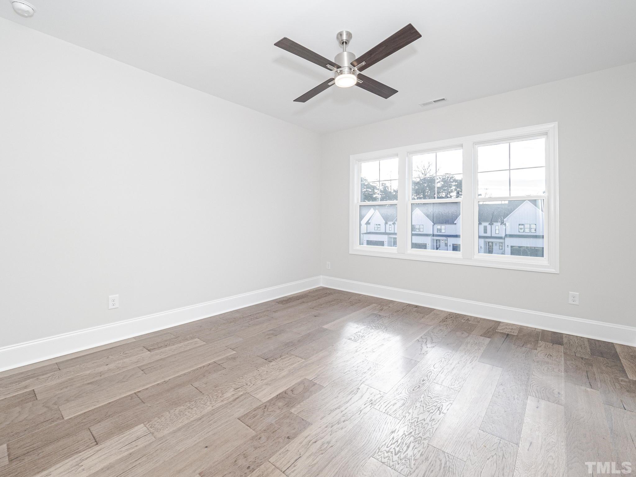 4920 Trek Lane Raleigh, NC 27606 - Photo 21 of 31 an empty room with wooden floor and windows