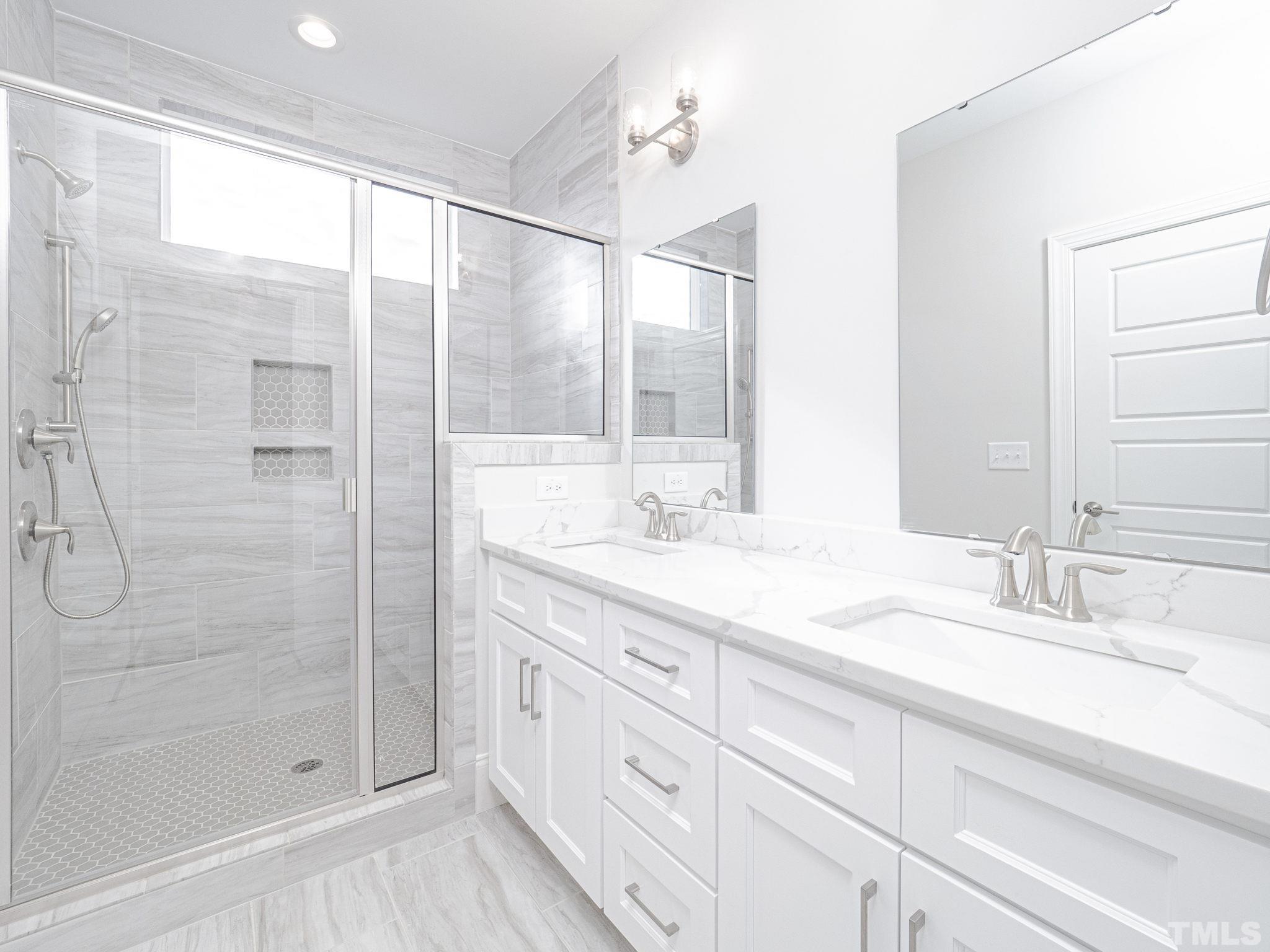 4920 Trek Lane Raleigh, NC 27606 - Photo 24 of 31 a bathroom with a granite countertop sink a mirror a shower and vanity