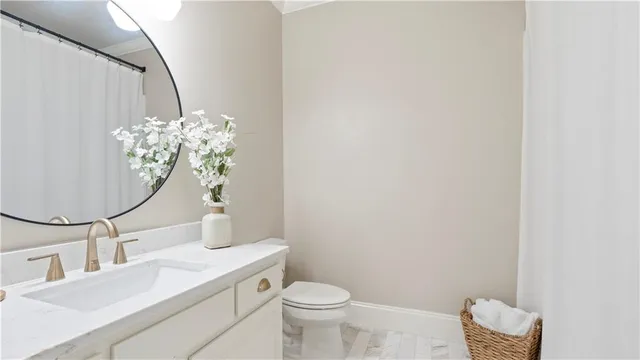 a bathroom with a granite countertop toilet sink and mirror