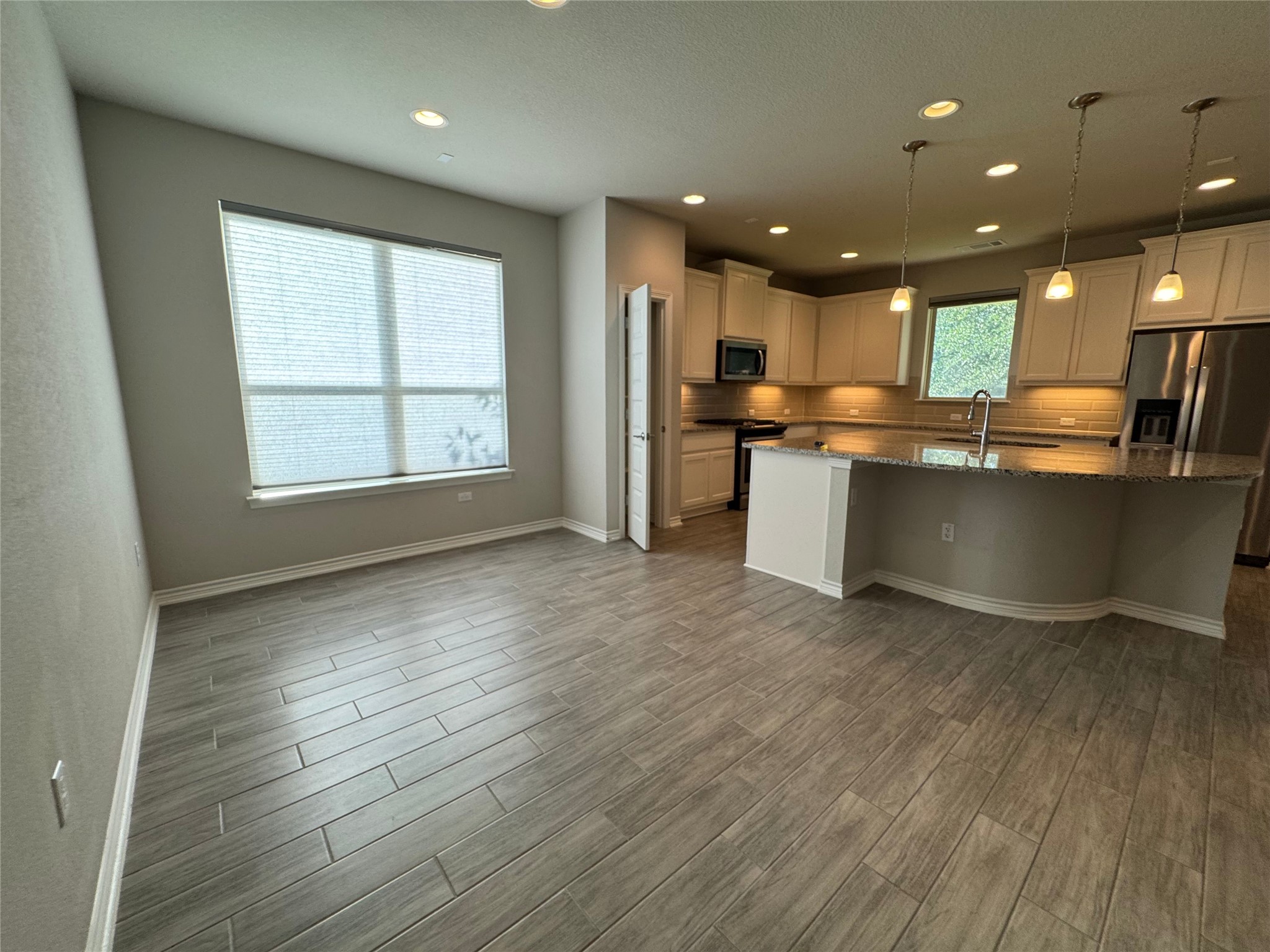 14100 McCoy Loop, Unit 1 Austin, TX 78717 - Photo 5 of 39 An open-concept living space with a modern kitchen island and elegant pendant lighting.