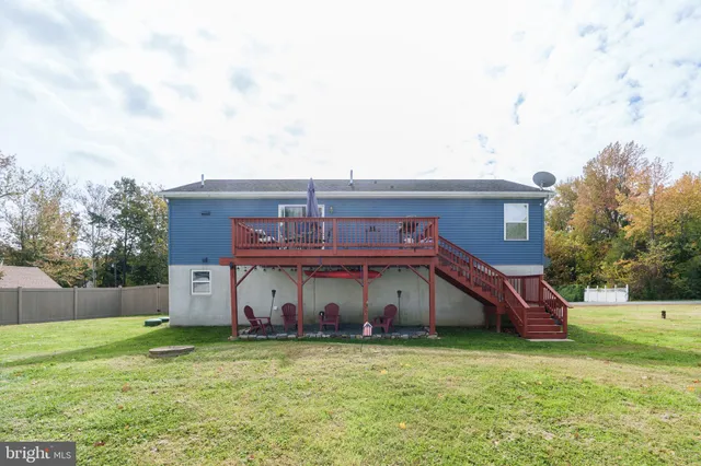 a view of a house with a big yard potted plants and a large tree