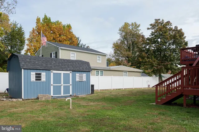 a view of a house with a yard and a large tree