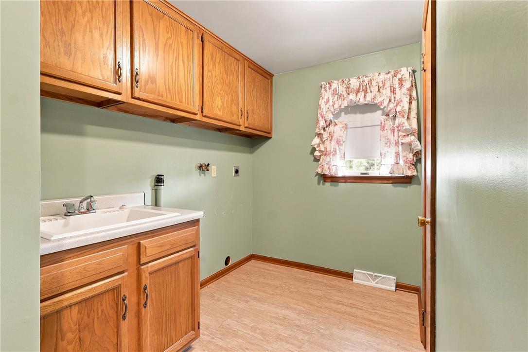 6090 Stone Post Road Bath, PA 18014 - Photo 23 of 57 Functional laundry room offers a convenient utility sink, ample cabinetry, and a bright window.