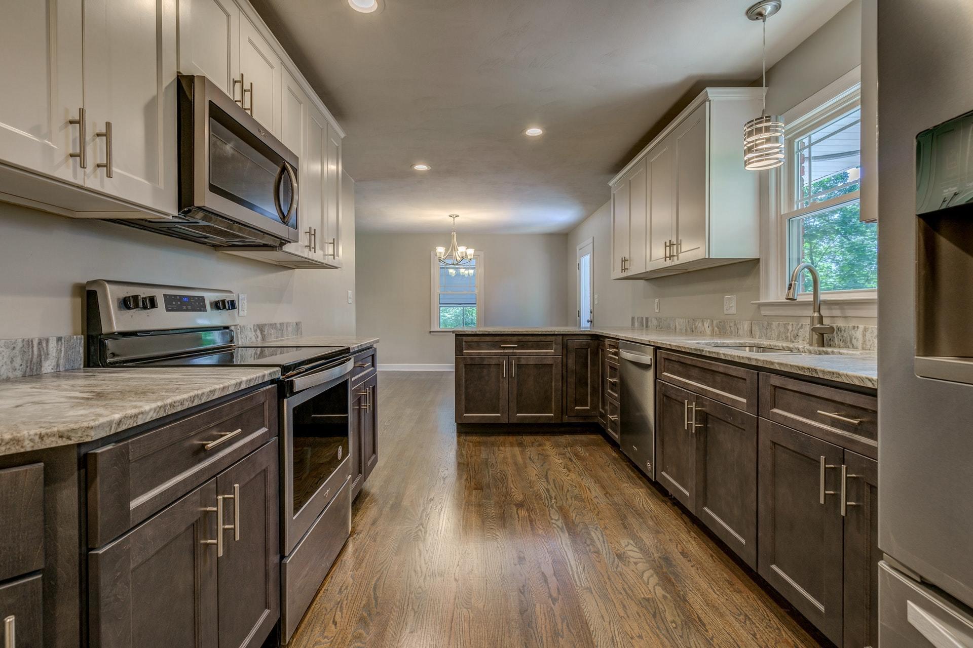 3585 Forester Road Southwest Roanoke, VA 24018 - Photo 12 of 38 a kitchen with stainless steel appliances granite countertop wooden cabinets a stove top oven a sink and dishwasher a oven with wooden floors