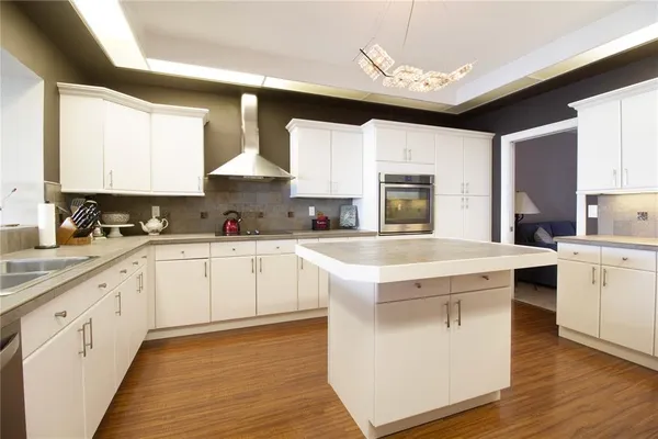 a kitchen with stainless steel appliances granite countertop a sink a stove and a refrigerator