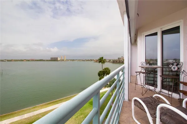a balcony with wooden floor table and chairs