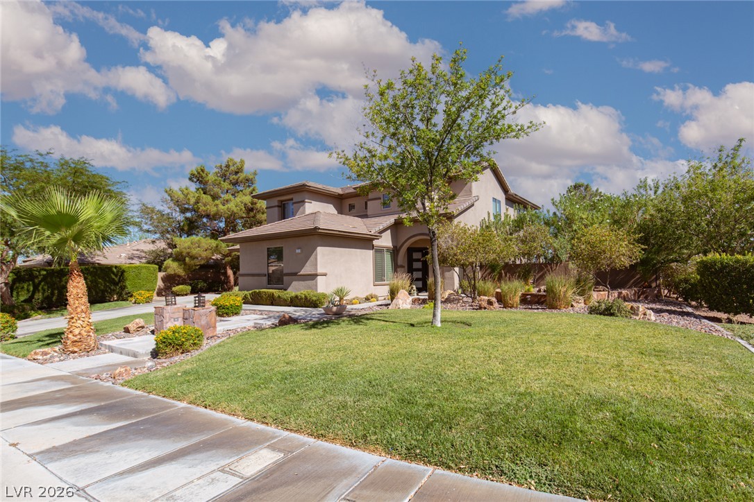 22 Douglas Grove Road Henderson, NV 89052 - Photo 17 of 72 A well-maintained lawn and mature landscaping enhance this home's curb appeal, inviting a serene lifestyle.
