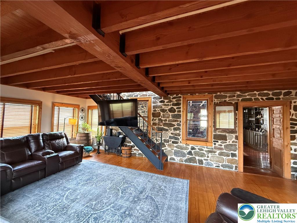 940 Jacktown Road Bangor, PA 18013 - Photo 12 of 33 Exposed beams and rustic stone walls create a cozy atmosphere in this living area.