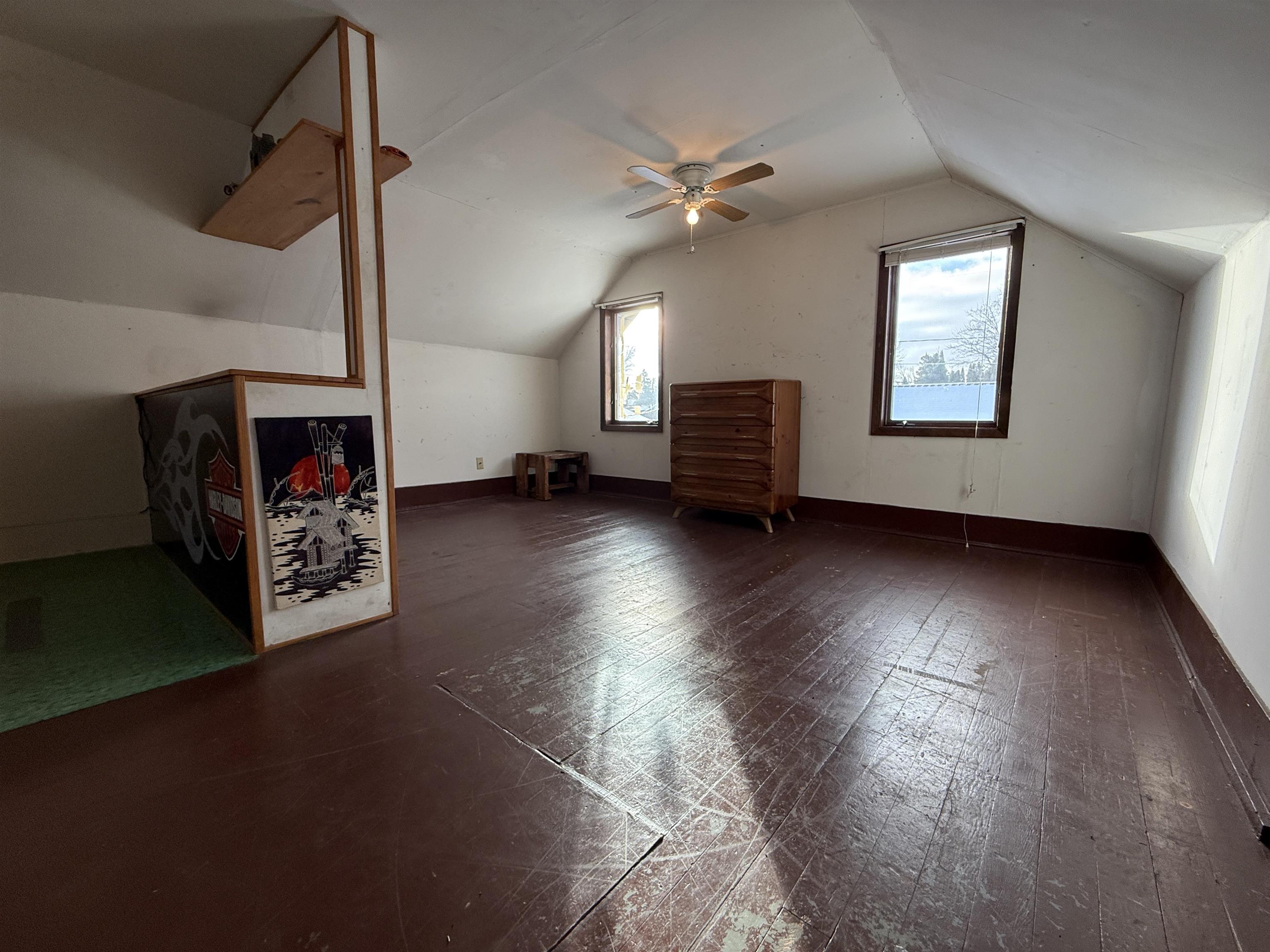 609 8th Street Northwest Chisholm, MN 55719 - Photo 22 of 26 Additional living space with lofted ceiling, dark wood-style floors, and a ceiling fan