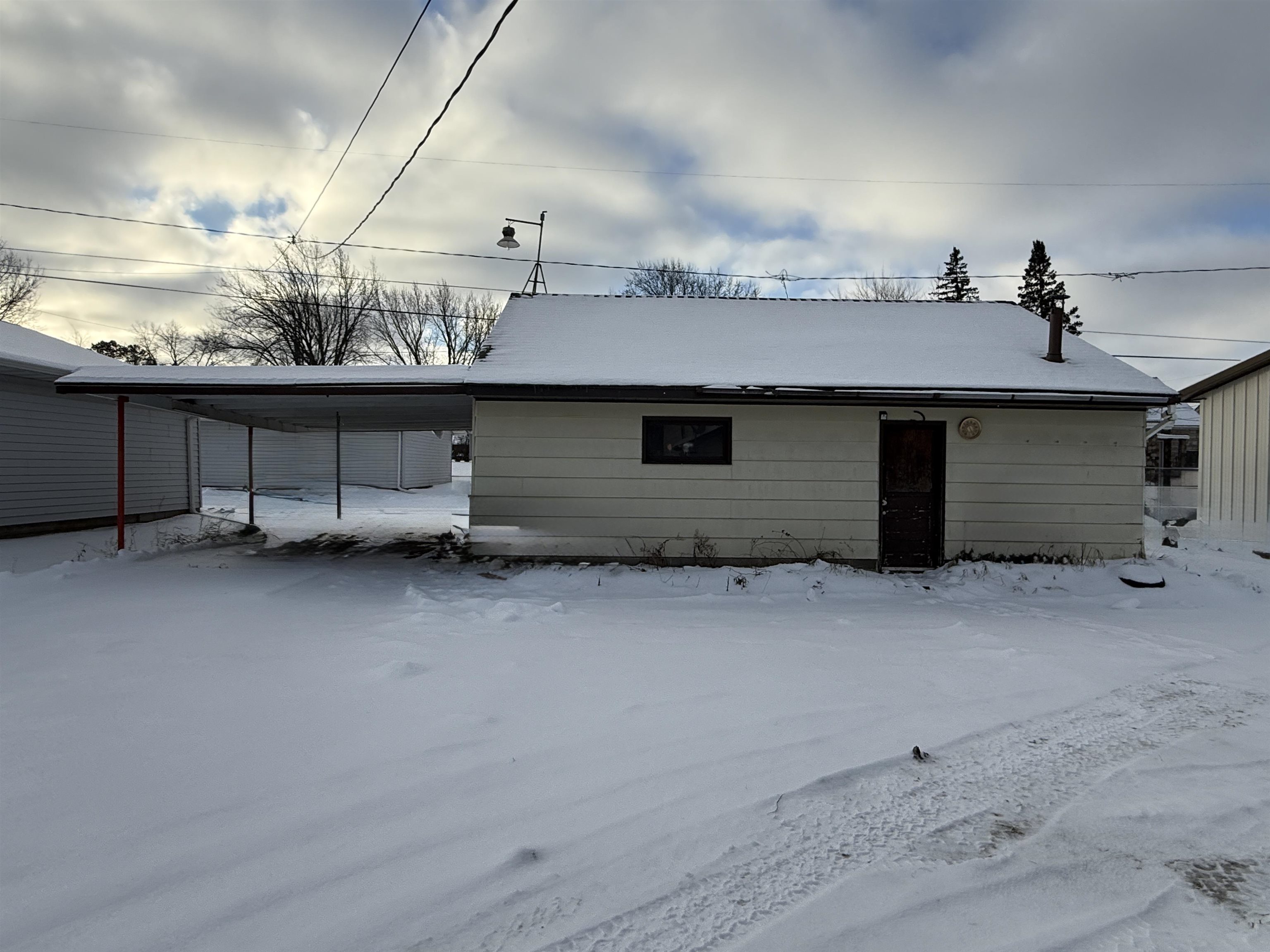 609 8th Street Northwest Chisholm, MN 55719 - Photo 4 of 26 Snow covered property featuring a carport