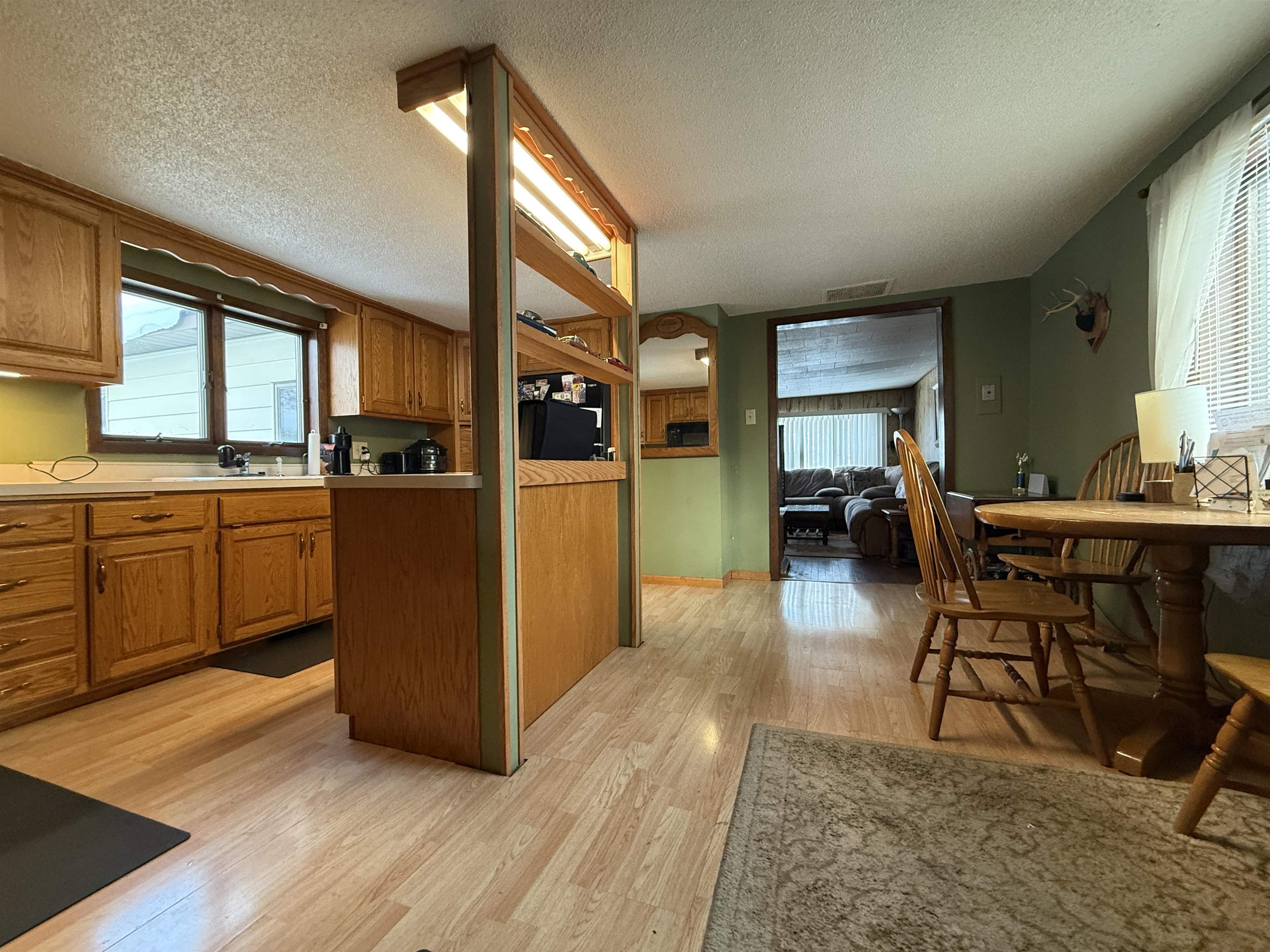 609 8th Street Northwest Chisholm, MN 55719 - Photo 8 of 26 Kitchen with brown cabinetry, light countertops, light wood-type flooring, and a textured ceiling
