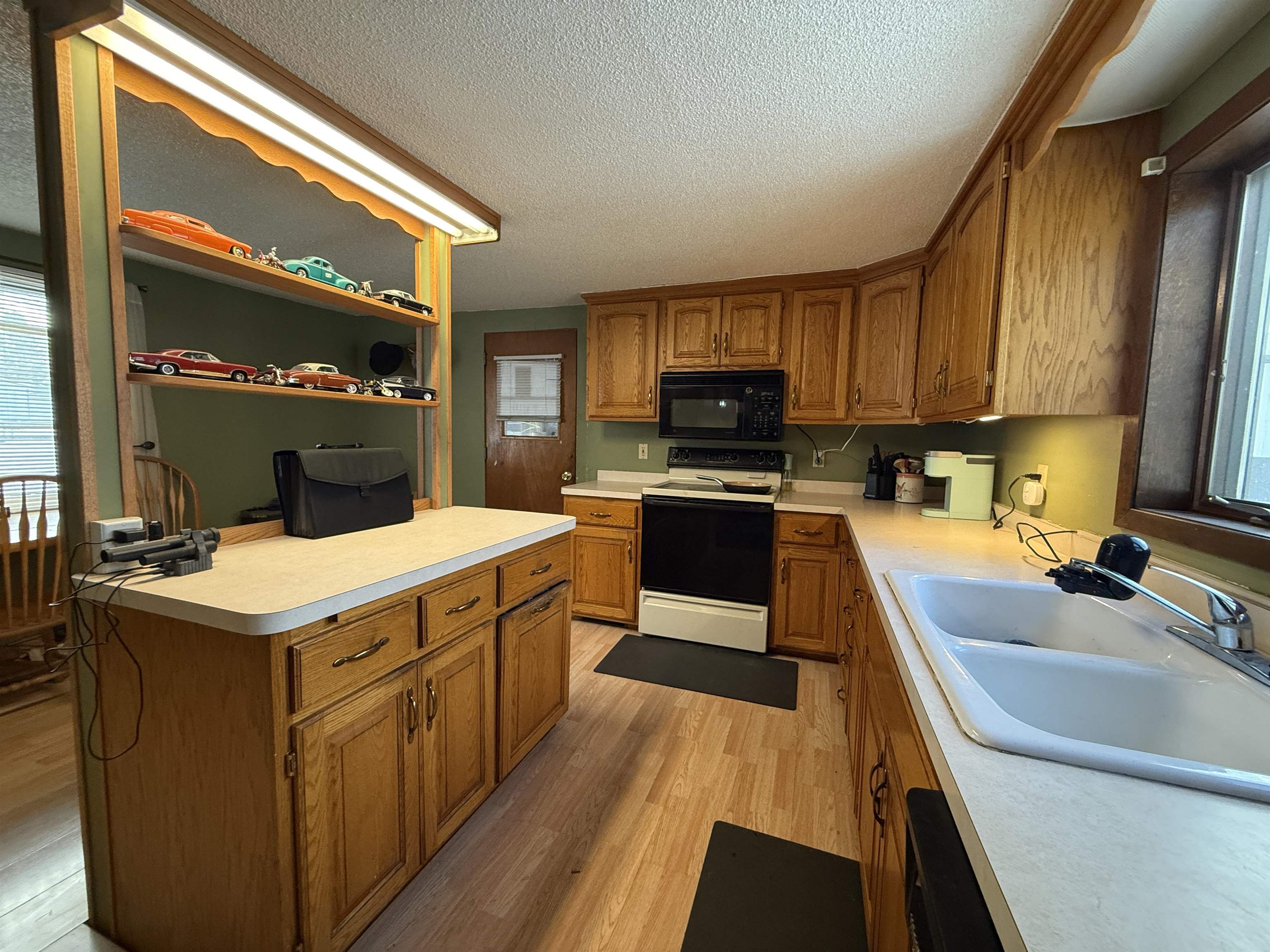 609 8th Street Northwest Chisholm, MN 55719 - Photo 10 of 26 Kitchen with plenty of natural light, range with electric stovetop, light countertops, and a textured ceiling