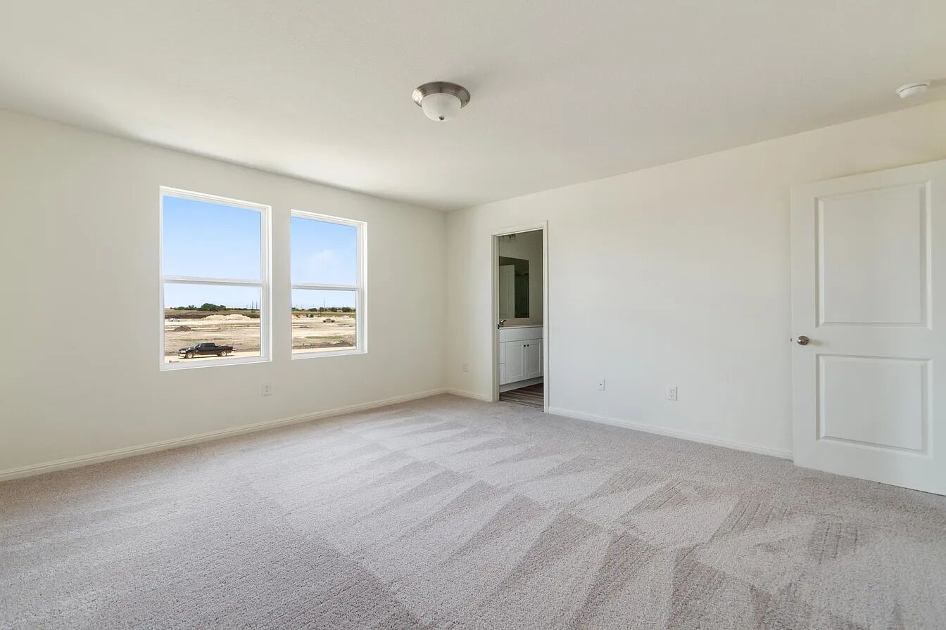101 Aoudad Road Hutto, TX 78634 - Photo 21 of 39 A spacious, naturally illuminated room featuring plush carpeting and a convenient en-suite bathroom access.