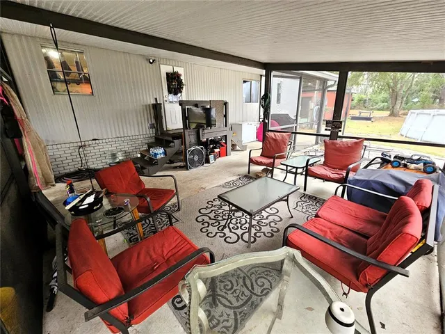 a living room with furniture a red lamp and a large window