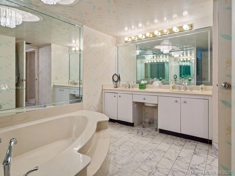 4000 Towerside Terrace, Unit 2302 Miami, FL 33138 - Photo 10 of 24 a bathroom with a bathtub a mirror a double vanity sink and mirror