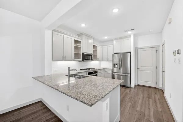 a kitchen with stainless steel appliances granite countertop a refrigerator and a sink