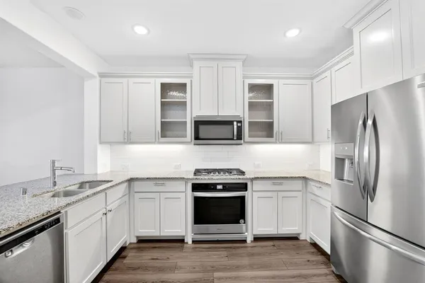 a kitchen with stainless steel appliances a stove microwave and sink