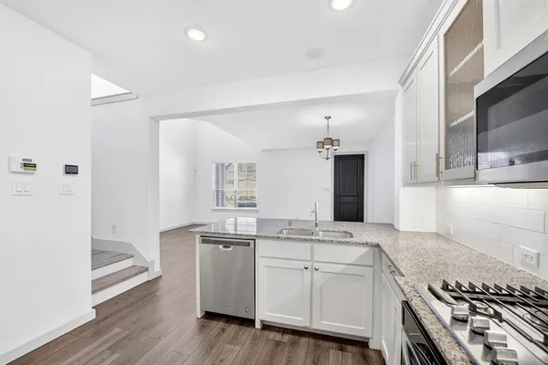 a view of kitchen with granite countertop cabinets and refrigerator