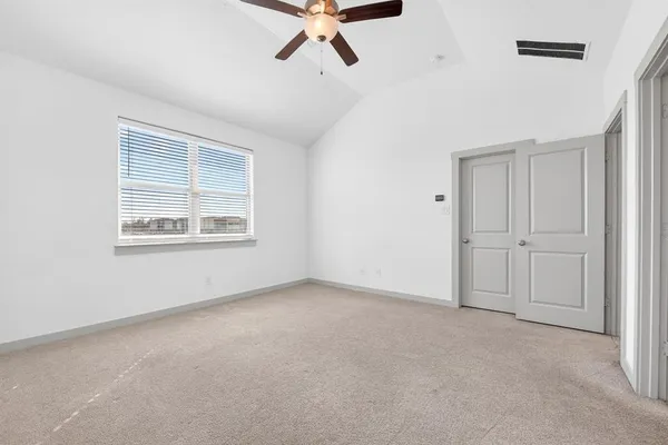 an empty room with a ceiling fan and window