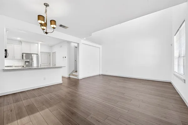 an empty room with wooden floor closet and windows