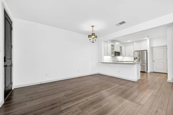 an empty room with wooden floor and ceiling fan