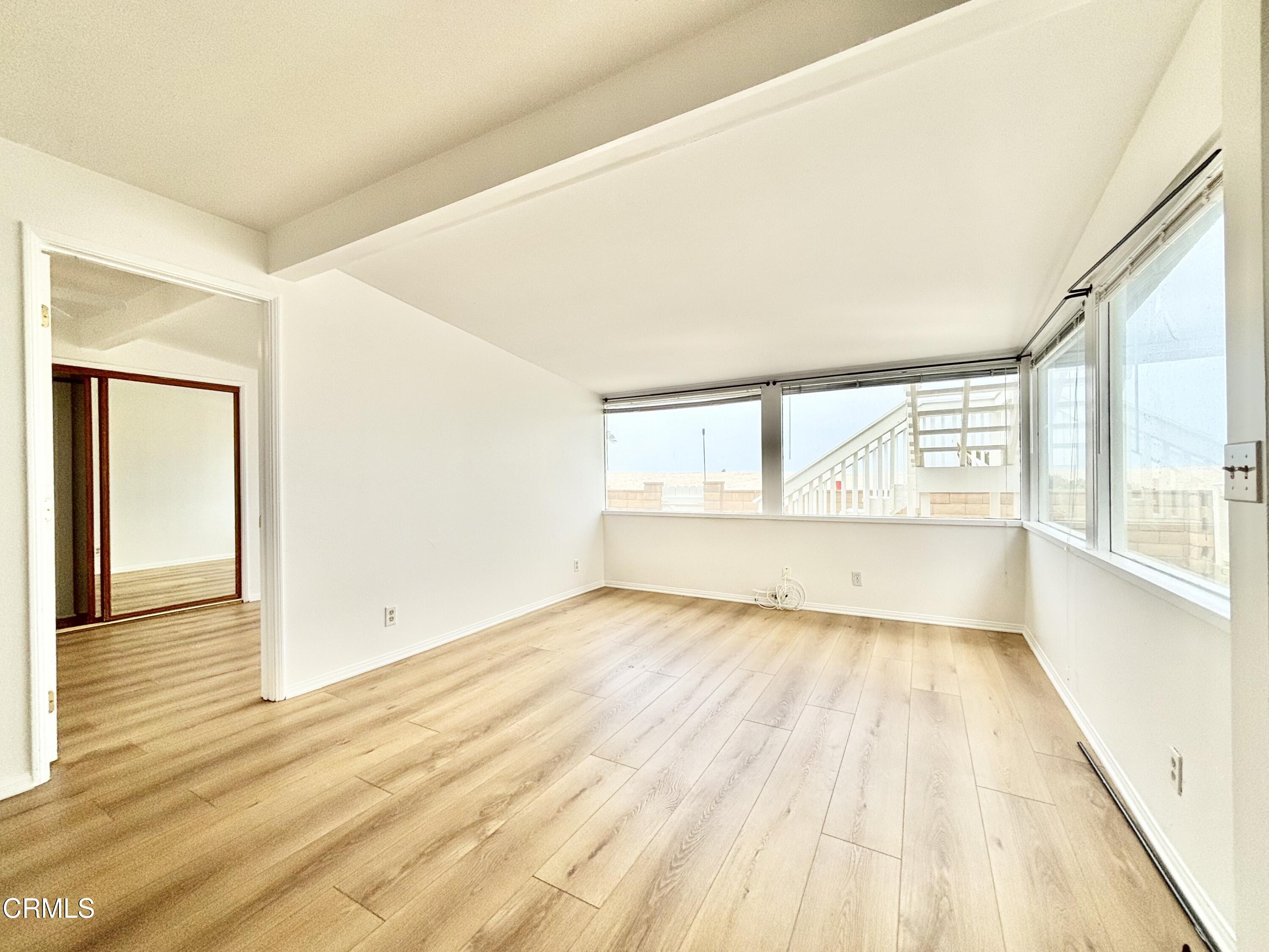4029 Ocean Drive Oxnard, CA 93035 - Photo 12 of 20 a view of an empty room with wooden floor and a window