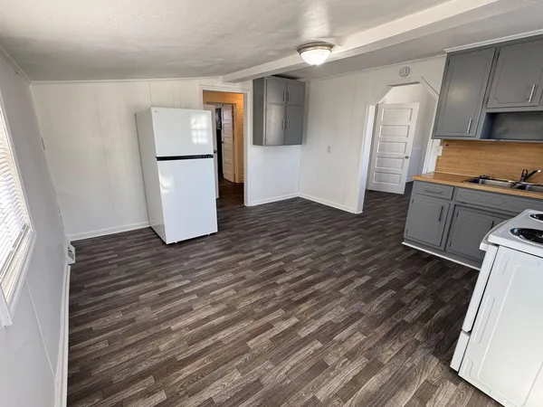 a kitchen with a refrigerator and a stove top oven