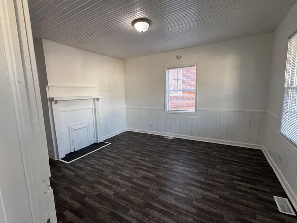an empty room with wooden floor and window